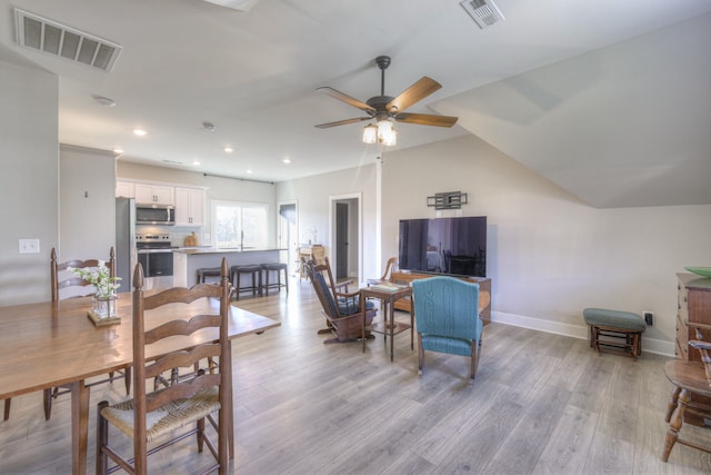 dining room featuring ceiling fan, light hardwood / wood-style flooring, and vaulted ceiling