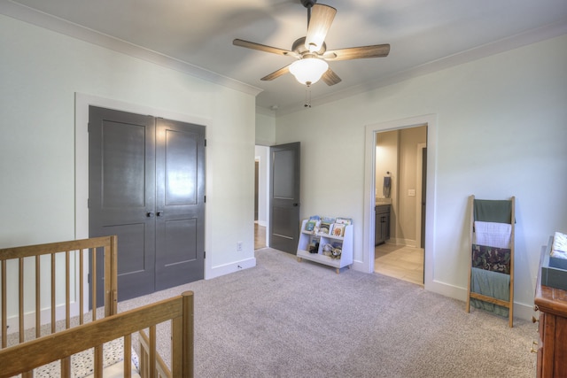 bedroom featuring crown molding, ceiling fan, a closet, and light colored carpet