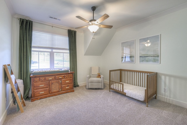 carpeted bedroom featuring ceiling fan, vaulted ceiling, ornamental molding, and a nursery area