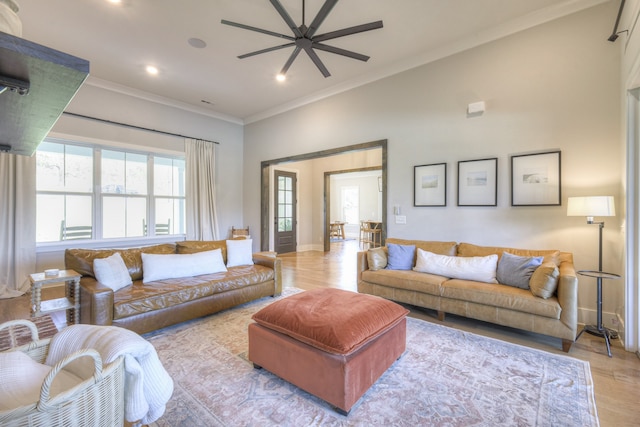 living room featuring light hardwood / wood-style flooring, ceiling fan, and crown molding