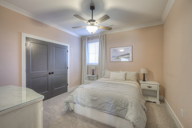 carpeted bedroom featuring ceiling fan, a closet, and ornamental molding