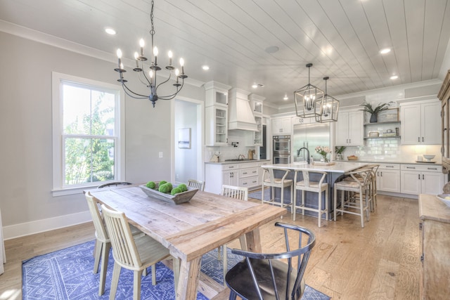 dining space with wood ceiling, crown molding, and light hardwood / wood-style flooring