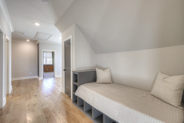 bedroom featuring light hardwood / wood-style floors, crown molding, and vaulted ceiling