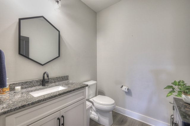 bathroom featuring toilet, vanity, and hardwood / wood-style flooring