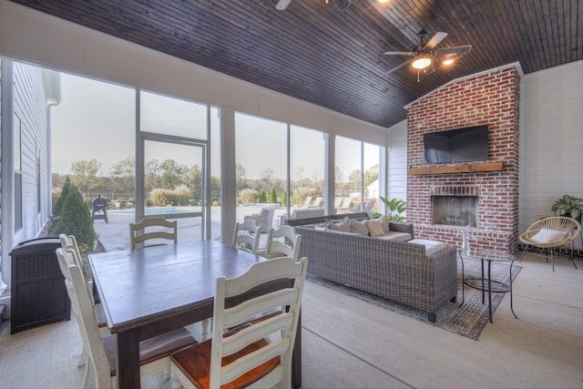 interior space featuring an outdoor brick fireplace, vaulted ceiling, ceiling fan, and wooden ceiling