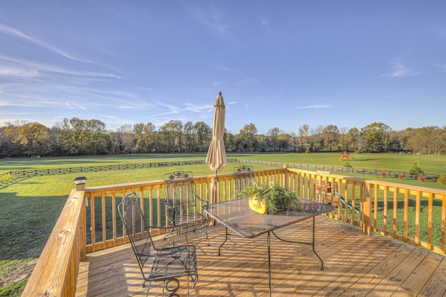 wooden deck featuring a yard and a rural view