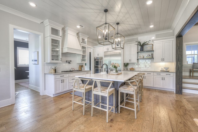 kitchen with white cabinets, light hardwood / wood-style floors, and appliances with stainless steel finishes