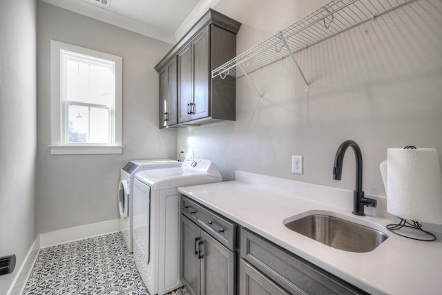 laundry room featuring cabinets, washer and clothes dryer, and sink