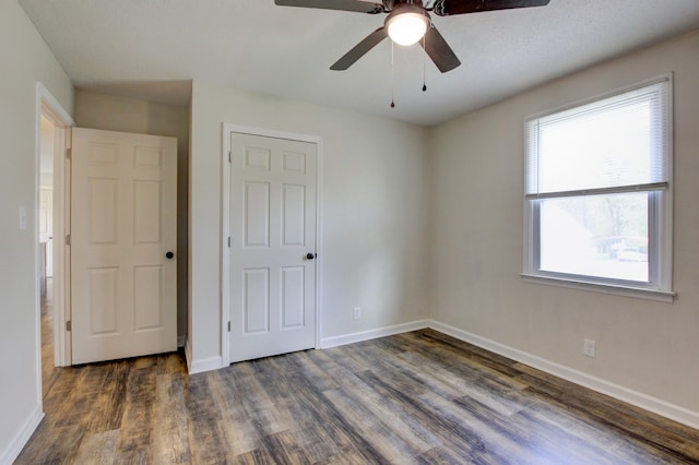 unfurnished bedroom featuring ceiling fan, dark hardwood / wood-style flooring, and a textured ceiling