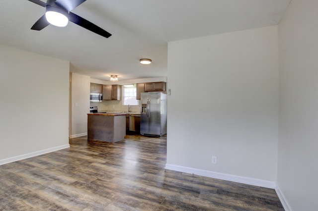 unfurnished living room featuring ceiling fan, dark hardwood / wood-style flooring, and sink