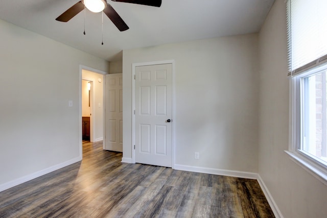 unfurnished bedroom with dark hardwood / wood-style floors, multiple windows, and ceiling fan