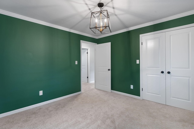 unfurnished bedroom with a chandelier, light colored carpet, a closet, and ornamental molding