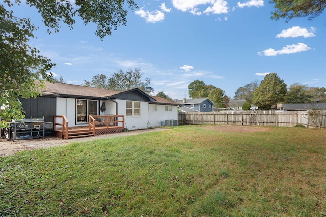 back of house featuring a wooden deck, a yard, and central AC