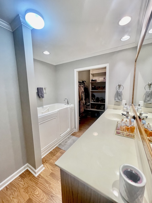 bathroom featuring hardwood / wood-style floors, vanity, a bath, and crown molding