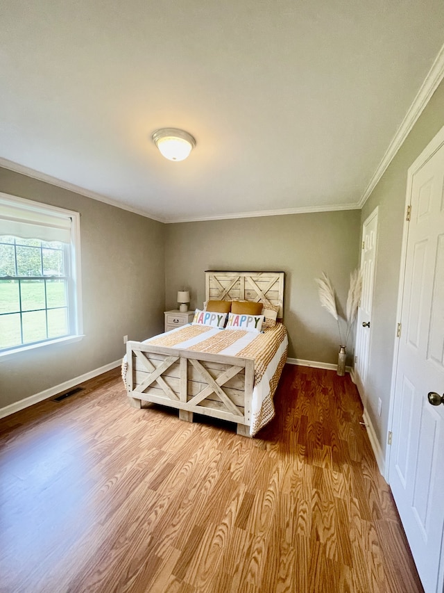 bedroom with crown molding and hardwood / wood-style flooring