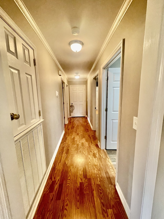 corridor featuring crown molding and light hardwood / wood-style flooring