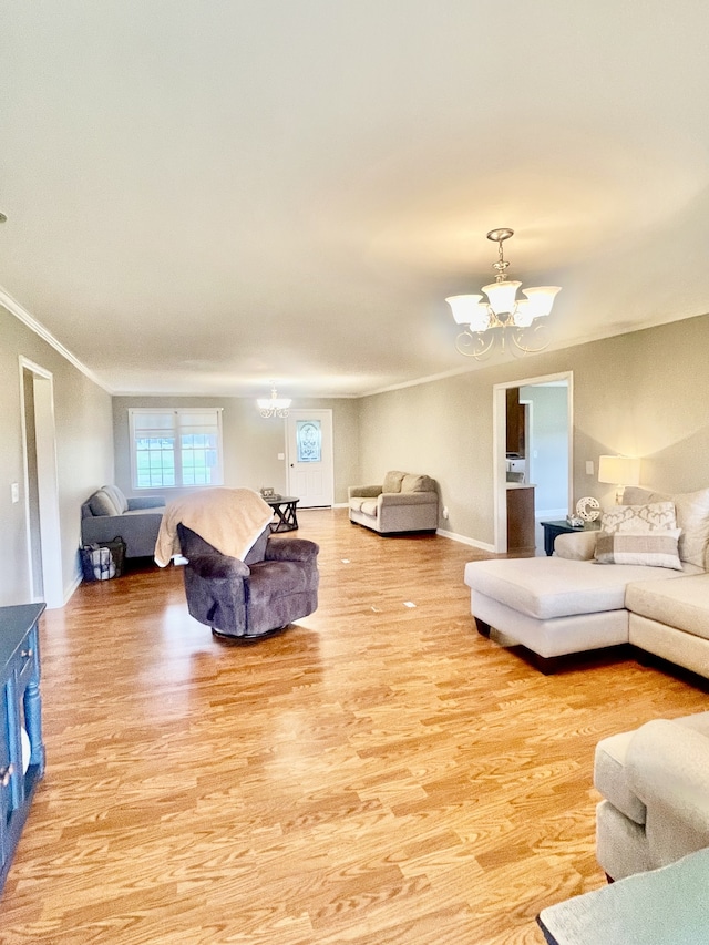 living room featuring light hardwood / wood-style floors, an inviting chandelier, and crown molding