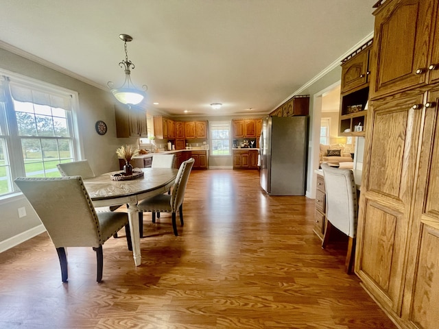 dining area with crown molding and hardwood / wood-style flooring