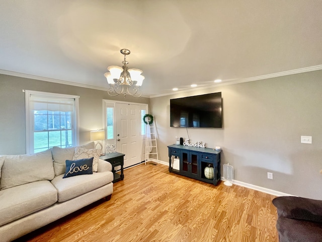 living room featuring a chandelier, crown molding, and light hardwood / wood-style flooring