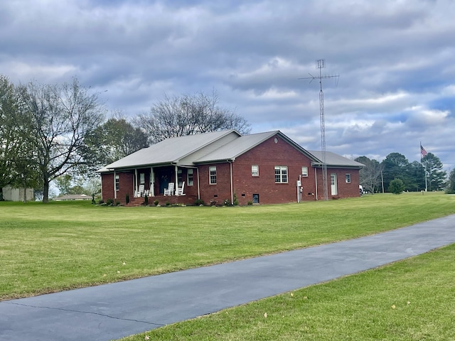 view of side of property with a lawn and covered porch