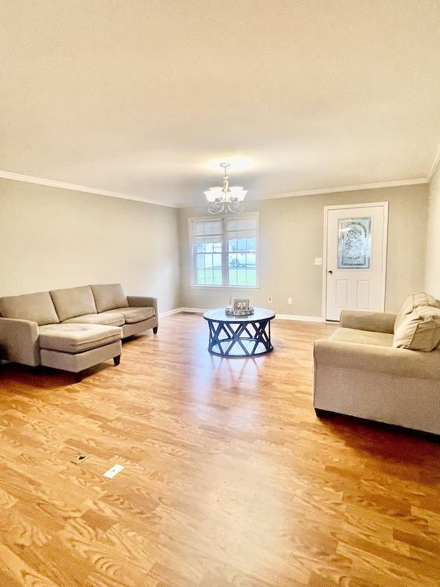 living room with crown molding, an inviting chandelier, and light wood-type flooring