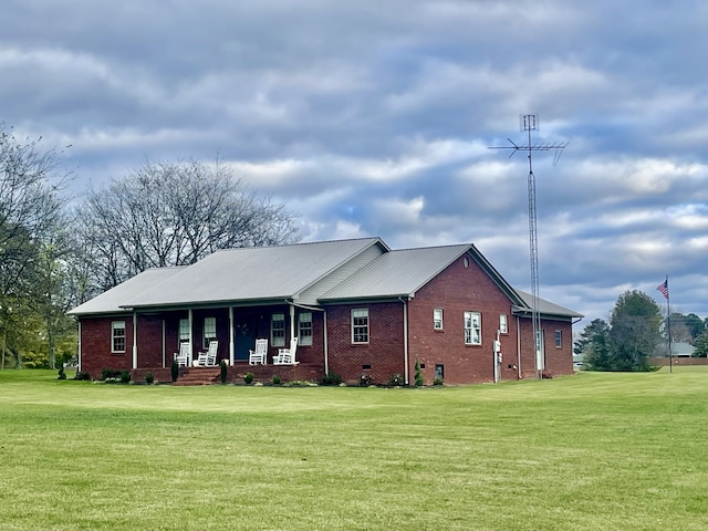 ranch-style house featuring covered porch and a front yard