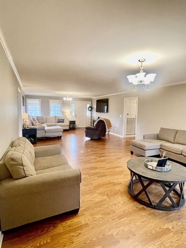 living room with a chandelier, light wood-type flooring, and crown molding