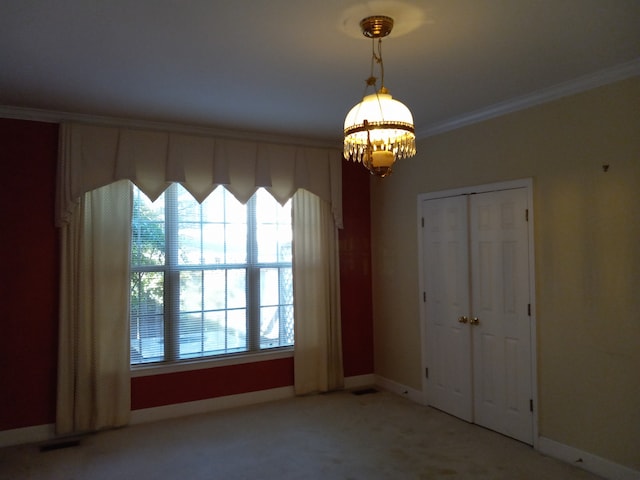 unfurnished room featuring carpet, crown molding, and a chandelier