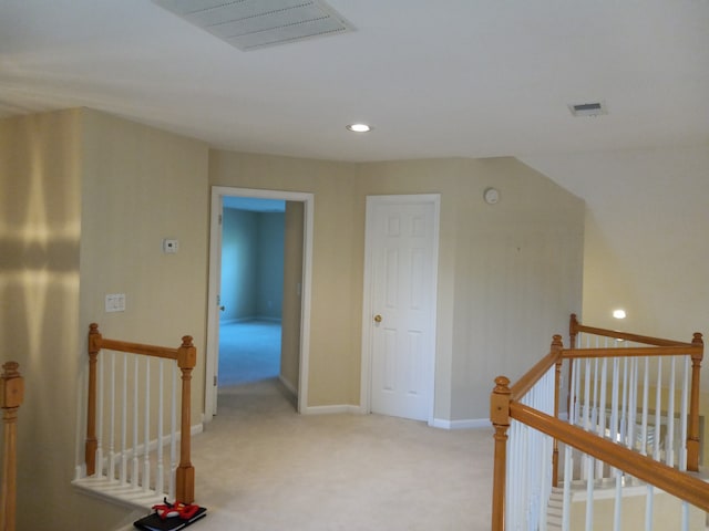 hall with light colored carpet