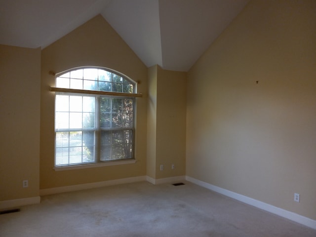 carpeted empty room with lofted ceiling