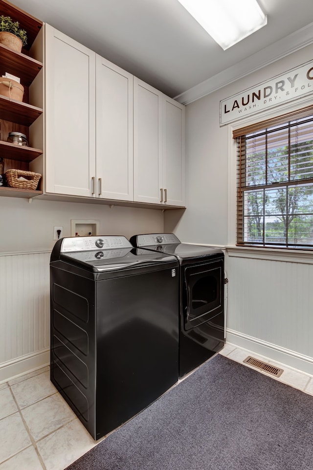 laundry area with light colored carpet, cabinets, ornamental molding, and washing machine and dryer