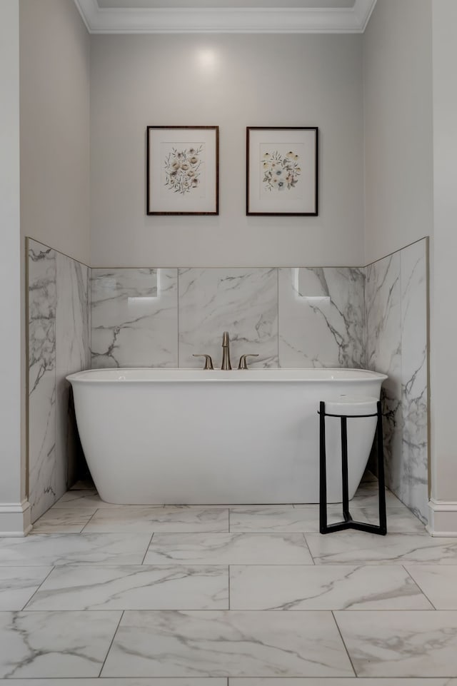 bathroom with crown molding, a bath, and tile walls