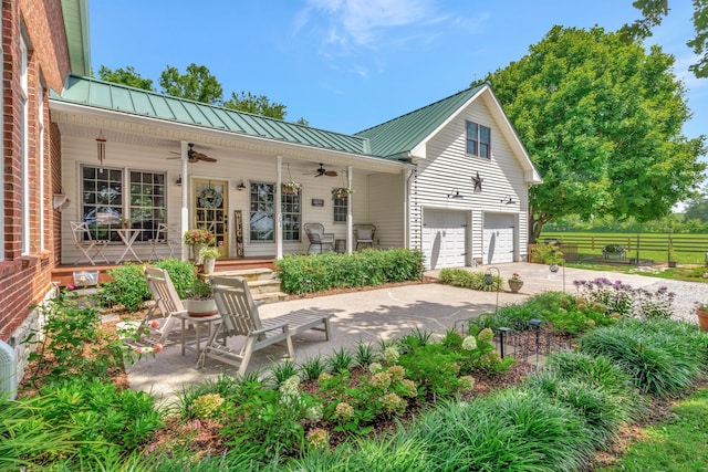 back of property with covered porch, a garage, and ceiling fan