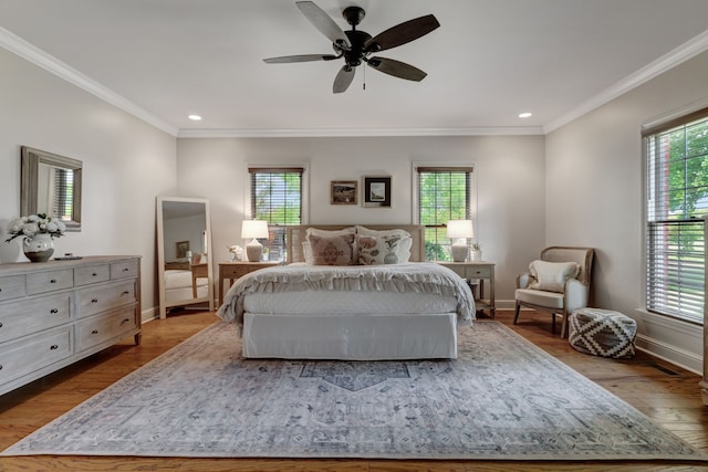 bedroom featuring ceiling fan, wood-type flooring, and multiple windows