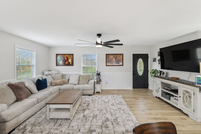 living room with ceiling fan, light wood-type flooring, and a wealth of natural light