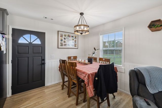 dining room featuring light hardwood / wood-style floors and a chandelier