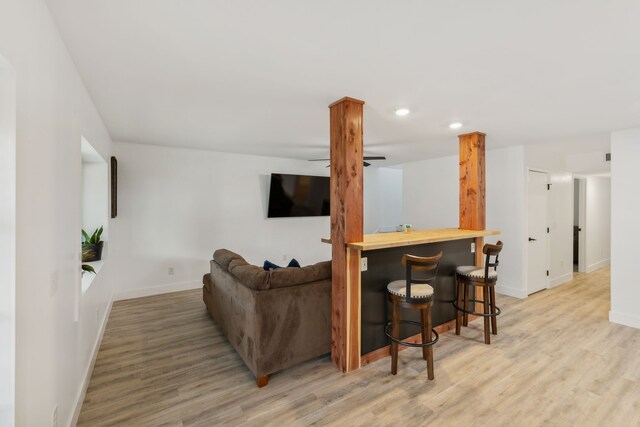 living room featuring bar area and light hardwood / wood-style floors