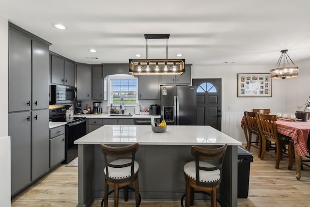 kitchen with pendant lighting, a center island, sink, and stainless steel appliances