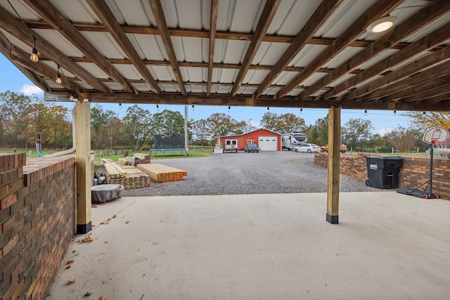 view of patio with a trampoline and a garage