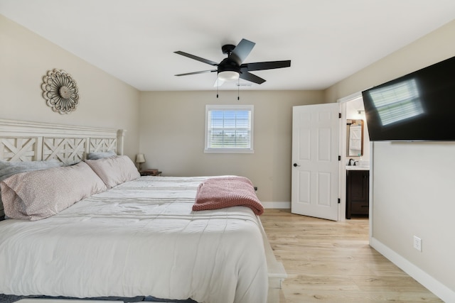 bedroom with ensuite bathroom, ceiling fan, sink, and light hardwood / wood-style flooring