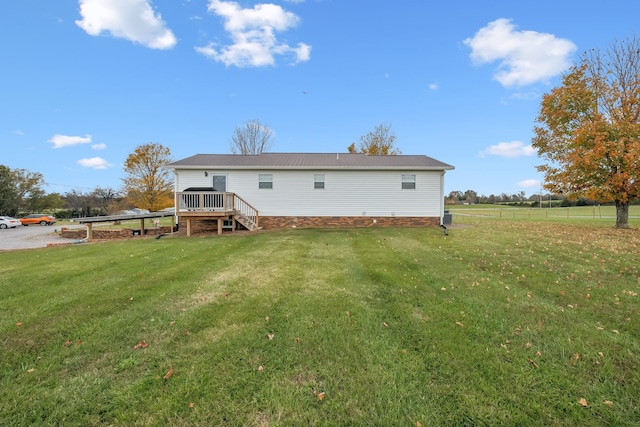 back of house with a wooden deck and a yard