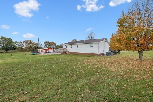 view of yard featuring a trampoline, a deck, and central AC unit