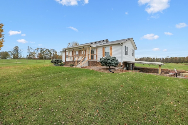 view of front of house featuring a front lawn, covered porch, and a rural view