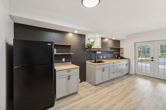 kitchen with french doors, wooden counters, black fridge, sink, and gray cabinets