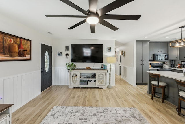 living room featuring light wood-type flooring and ceiling fan