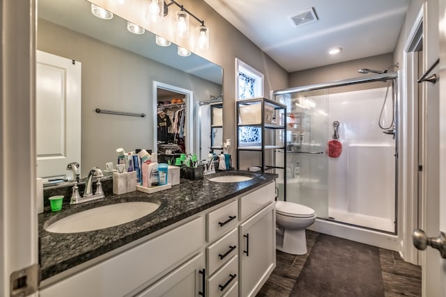 bathroom with vanity, toilet, and a shower with shower door