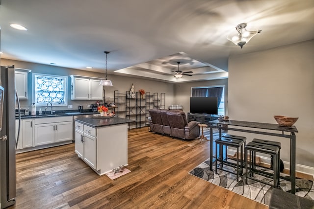 kitchen with white cabinetry, ceiling fan, hanging light fixtures, and dark hardwood / wood-style floors