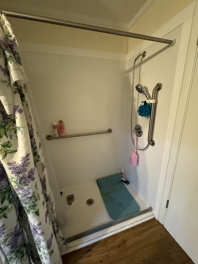 bathroom with crown molding, hardwood / wood-style floors, and walk in shower