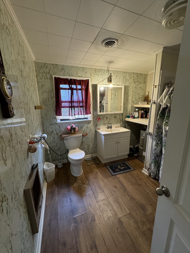 bathroom featuring hardwood / wood-style flooring, vanity, toilet, and crown molding