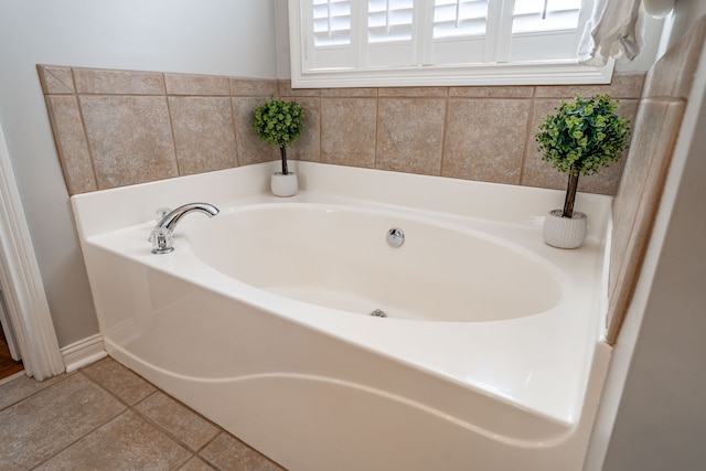 bathroom featuring a washtub, a healthy amount of sunlight, and tile patterned flooring